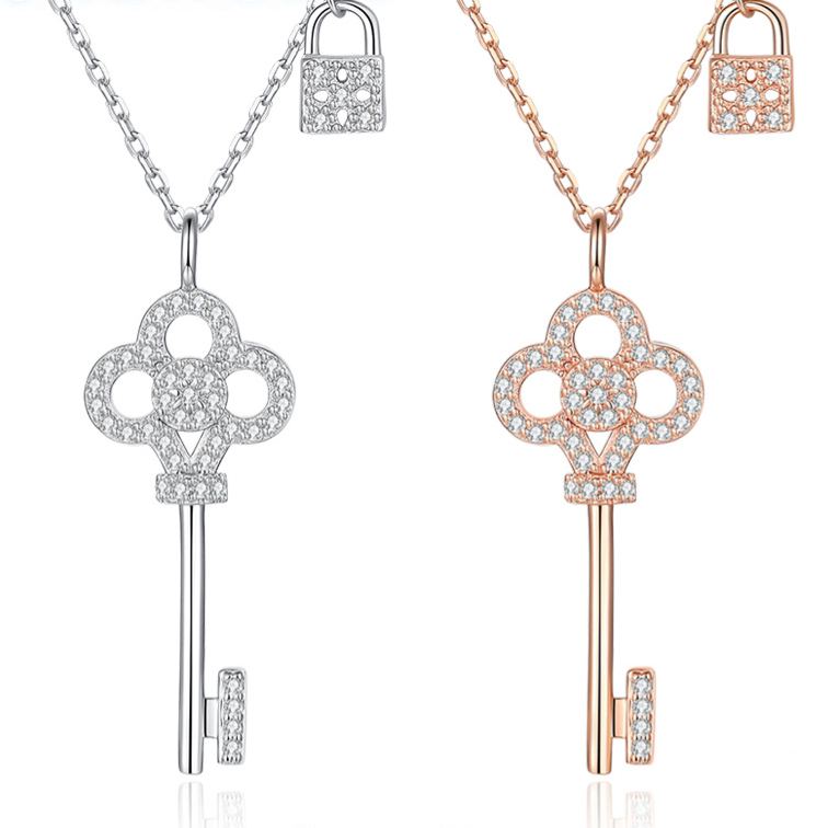 Silver and rose gold-plated zirconia key pendant necklaces on a white background